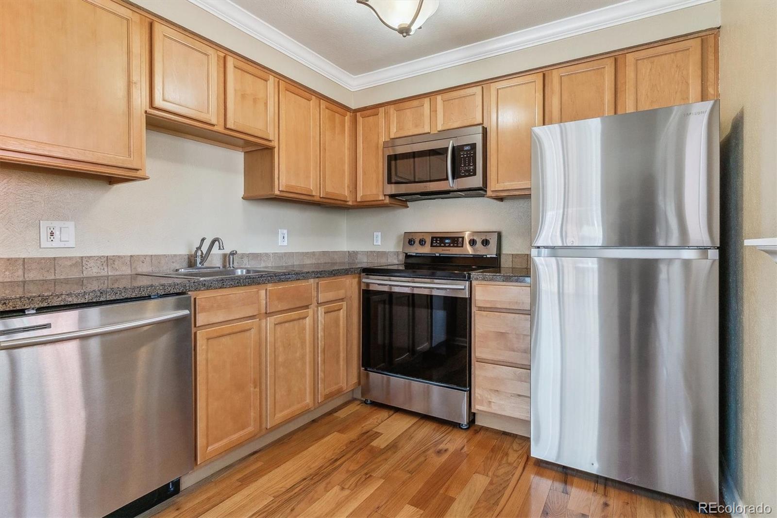 1330 Elizabeth Street, Unit 8 Denver, CO 80206 - Photo 8 of 15 a kitchen with granite countertop a refrigerator stove and microwave