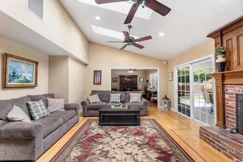 a kitchen with stainless steel appliances kitchen island granite countertop a stove a sink dishwasher and a refrigerator with wooden floor