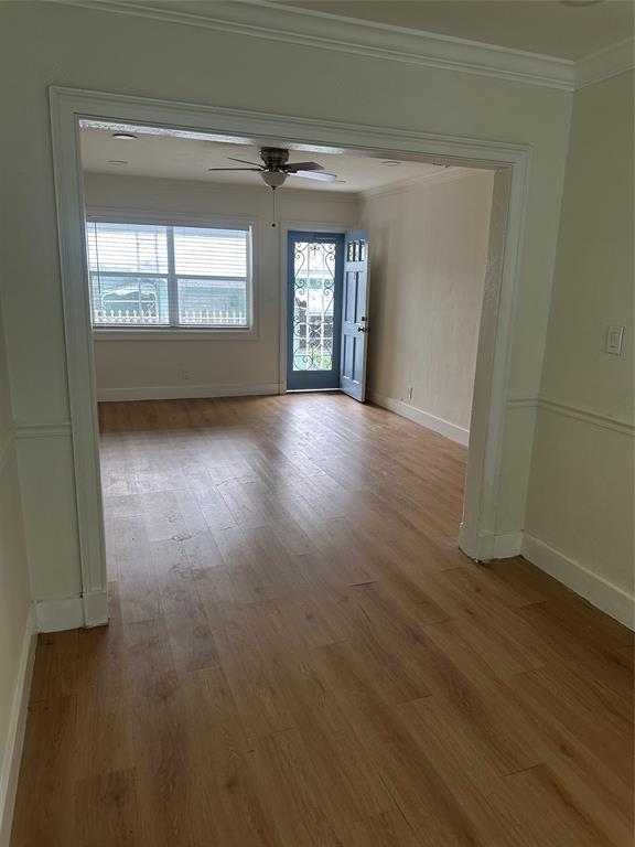 1242 Northeast 110th Street, Unit 2 Miami, FL 33161 - Photo 4 of 12 an empty room with wooden floor and windows
