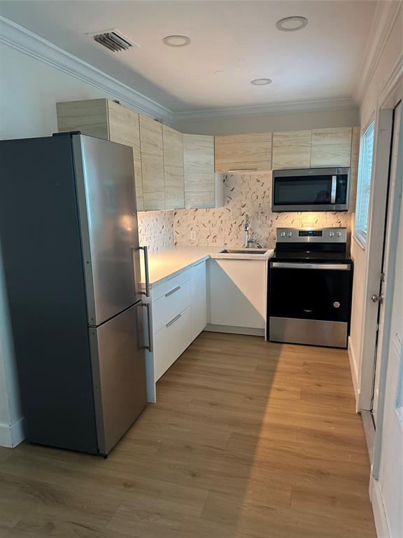 1242 Northeast 110th Street, Unit 2 Miami, FL 33161 - Photo 5 of 12 a kitchen with granite countertop a refrigerator and a stove top oven