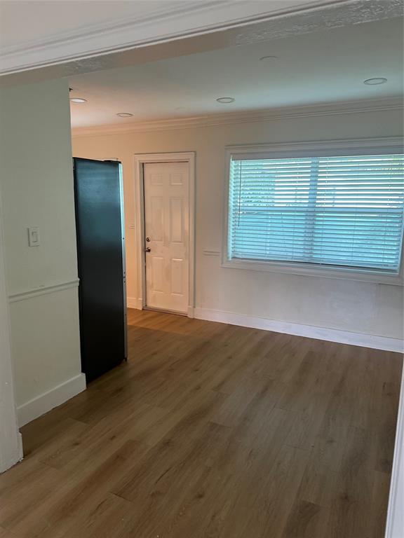 1242 Northeast 110th Street, Unit 2 Miami, FL 33161 - Photo 6 of 12 an empty room with wooden floor and windows