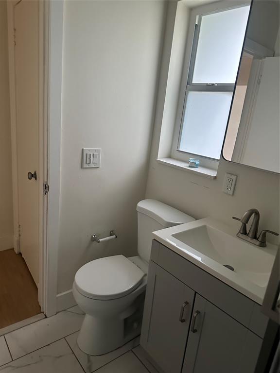 1242 Northeast 110th Street, Unit 2 Miami, FL 33161 - Photo 7 of 12 a bathroom with a toilet sink and mirror