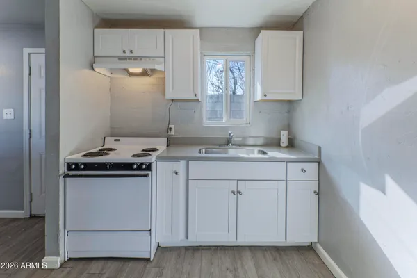 a kitchen with cabinets appliances and a sink