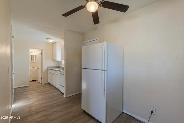 a view of a kitchen with a white cabinet and a chandelier fan