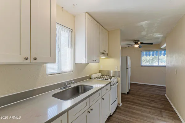 a kitchen that has a sink cabinets counter space and a window