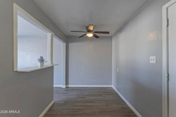 a living room with wooden floor and a ceiling fan