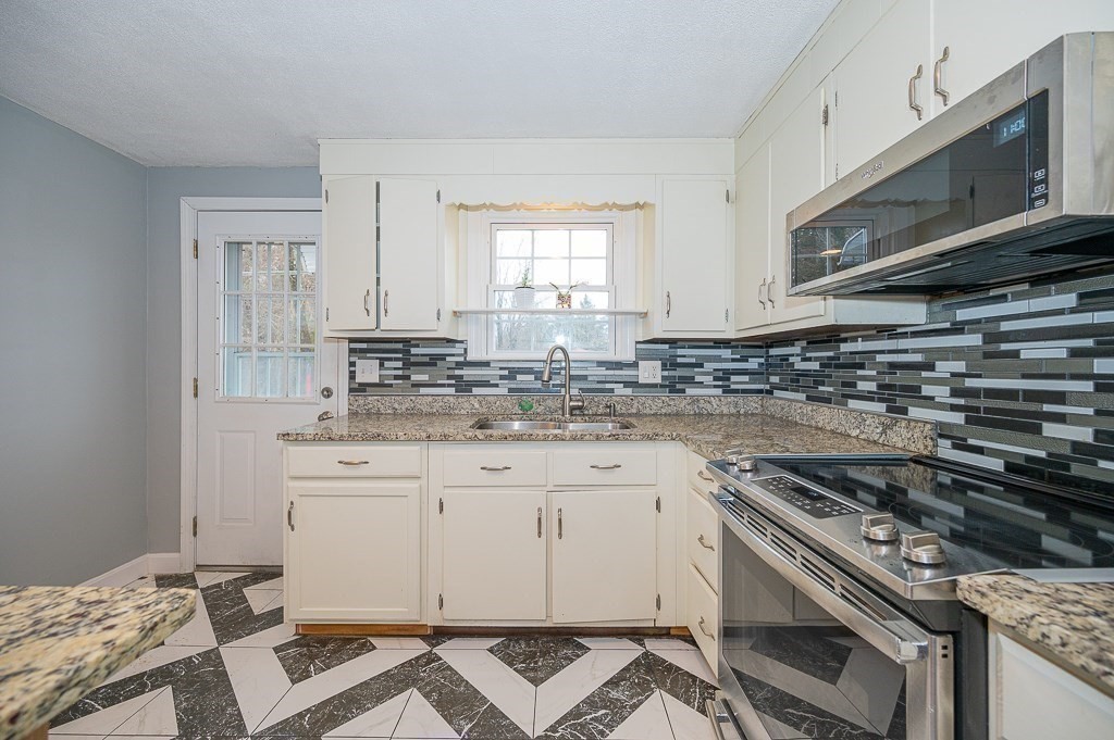 4 Kent Street Clinton, MA 01510 - Photo 14 of 39 a kitchen with granite countertop a stove sink and cabinets