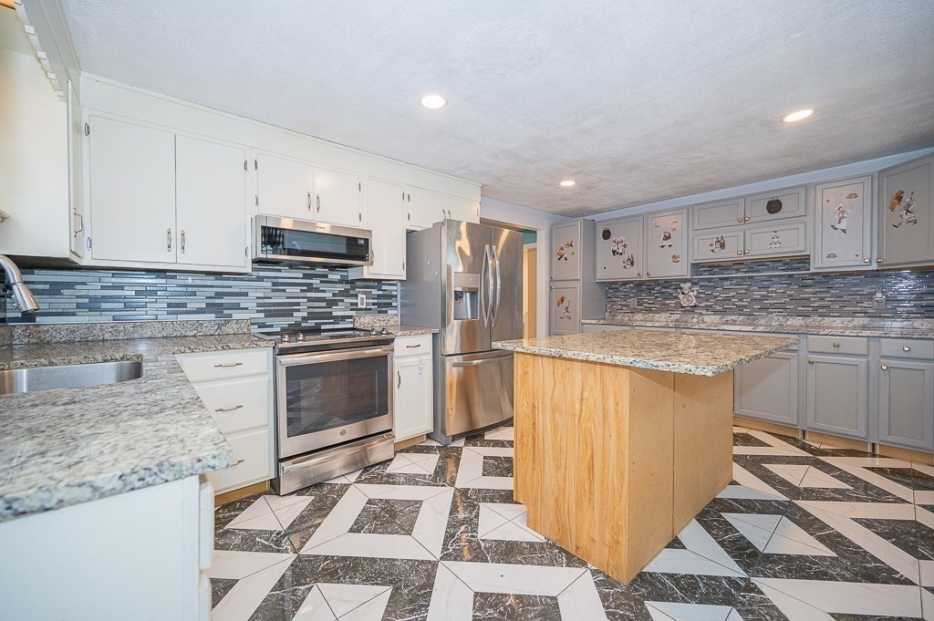 4 Kent Street Clinton, MA 01510 - Photo 17 of 39 a kitchen with stainless steel appliances granite countertop a stove a sink and a refrigerator