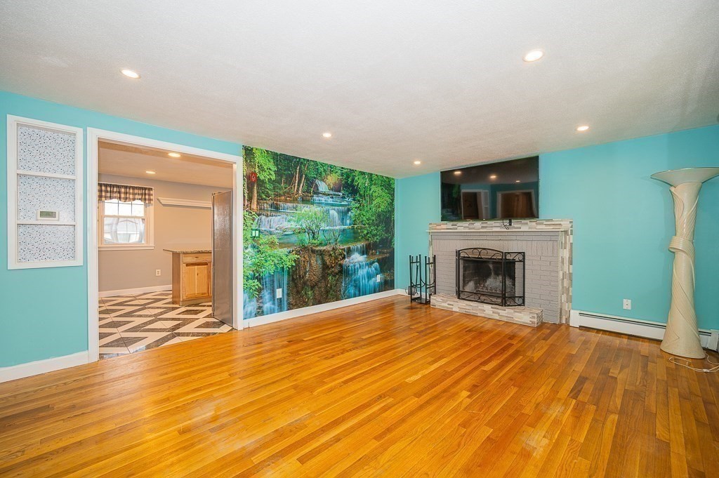 4 Kent Street Clinton, MA 01510 - Photo 9 of 39 a view of empty room with wooden floor and fireplace