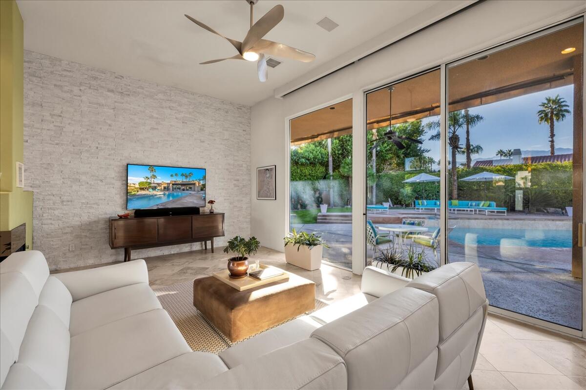 2 Silver Circle Rancho Mirage, CA 92270 - Photo 17 of 52 a living room with furniture a flat screen tv and a floor to ceiling window