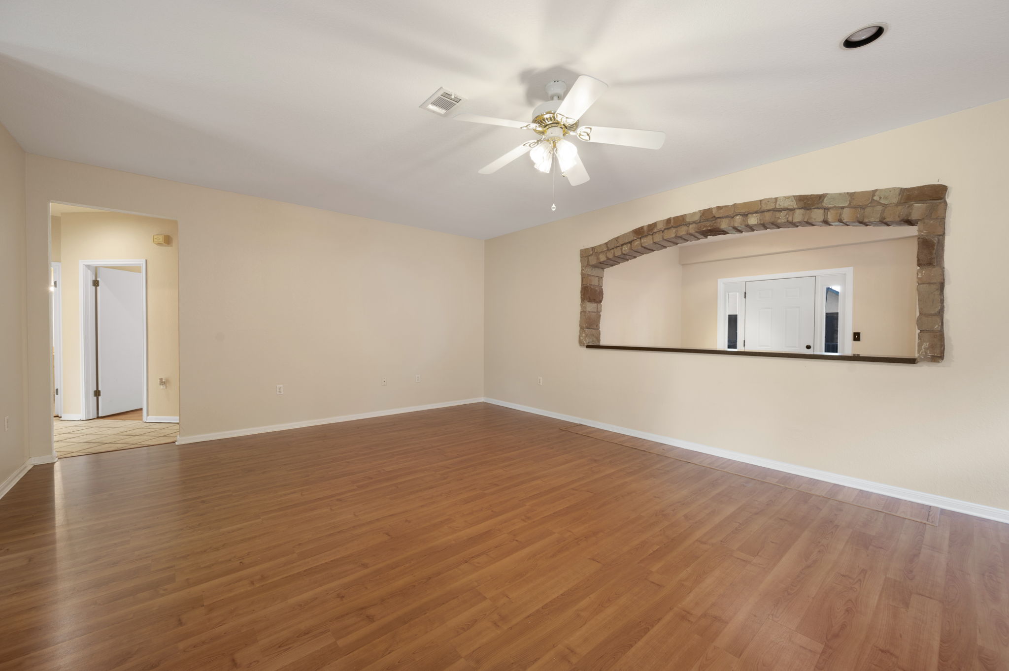 118 Bass Street Georgetown, TX 78633 - Photo 13 of 40 Well-lit living area showcases laminate wood flooring and a charming stone archway feature.