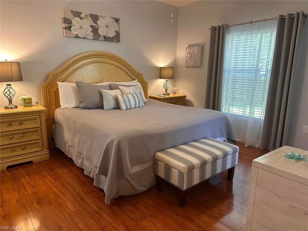 9185 Celeste Drive, Unit 101 Naples, FL 34113 - Photo 2 of 5 a bedroom with a bed and wooden floor