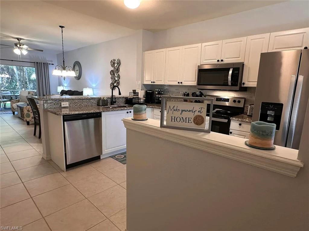 9185 Celeste Drive, Unit 101 Naples, FL 34113 - Photo 4 of 5 a kitchen with stainless steel appliances granite countertop a stove top oven a sink a counter space and cabinets