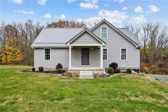 a front view of house with yard and outdoor seating