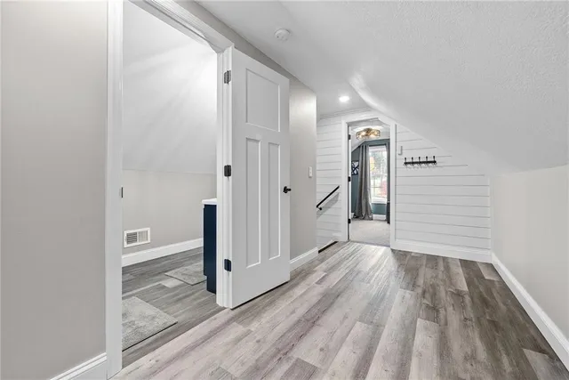 a view of a hallway with wooden floor and staircase