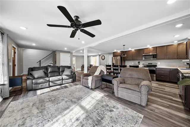 a living room with furniture kitchen view and a window