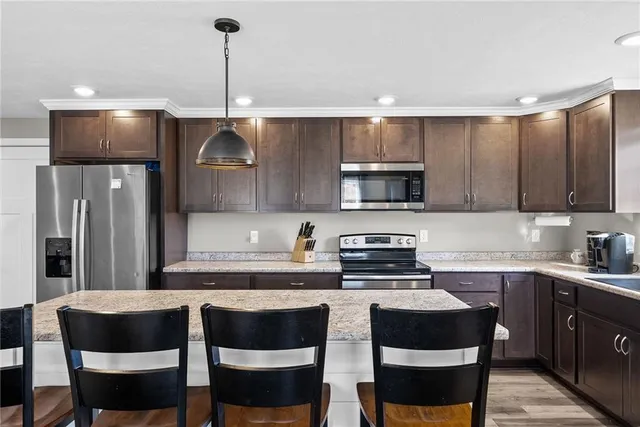a kitchen with granite countertop a sink cabinets and stainless steel appliances