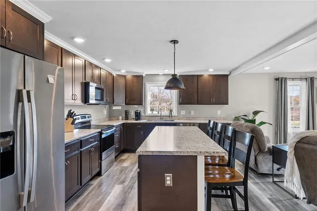 a kitchen with kitchen island a counter top space appliances and cabinets