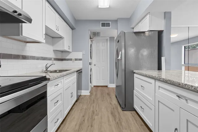 a kitchen with stainless steel appliances a refrigerator sink and stove