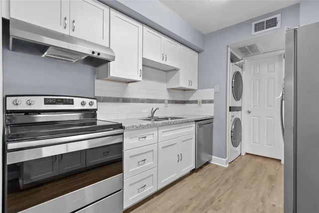 a kitchen with stainless steel appliances granite countertop a stove and a refrigerator