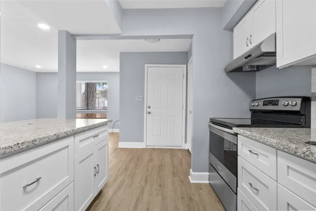 a kitchen with granite countertop wooden cabinets a sink and dishwasher