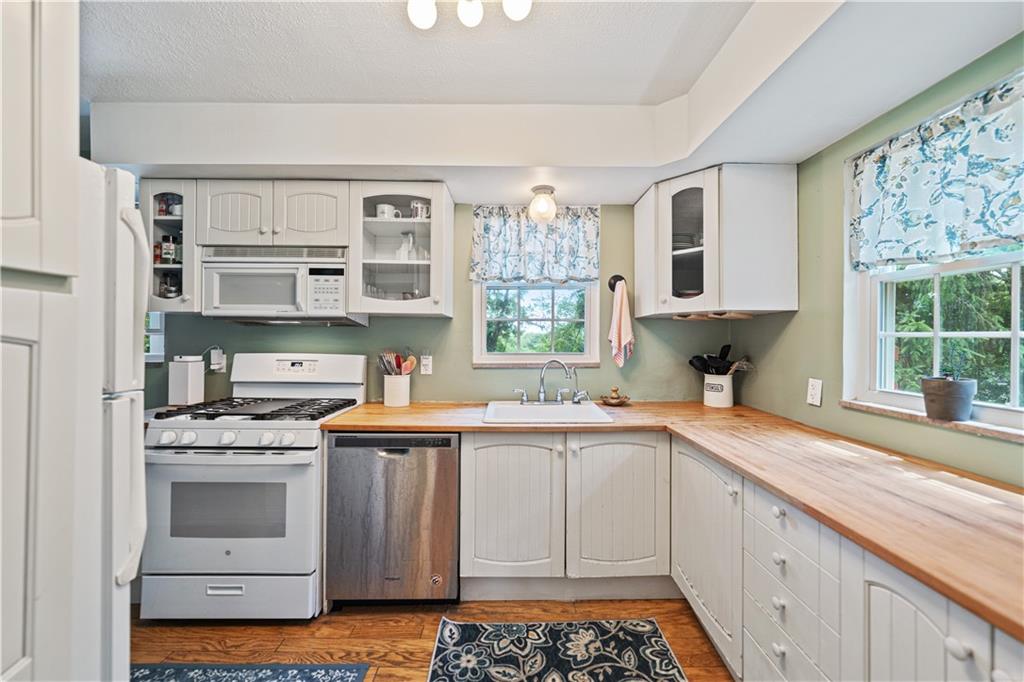 569 Kenilworth Drive Pittsburgh, PA 15228 - Photo 11 of 29 a kitchen with stainless steel appliances a white stove top oven cabinets a sink and a window