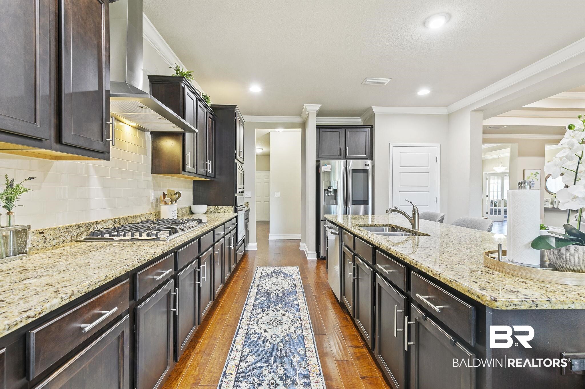 31500 Spoonbill Road Daphne, AL 36527 - Photo 19 of 85 Kitchen with stainless steel appliances, wall chimney exhaust hood, sink, and dark hardwood / wood-style floors