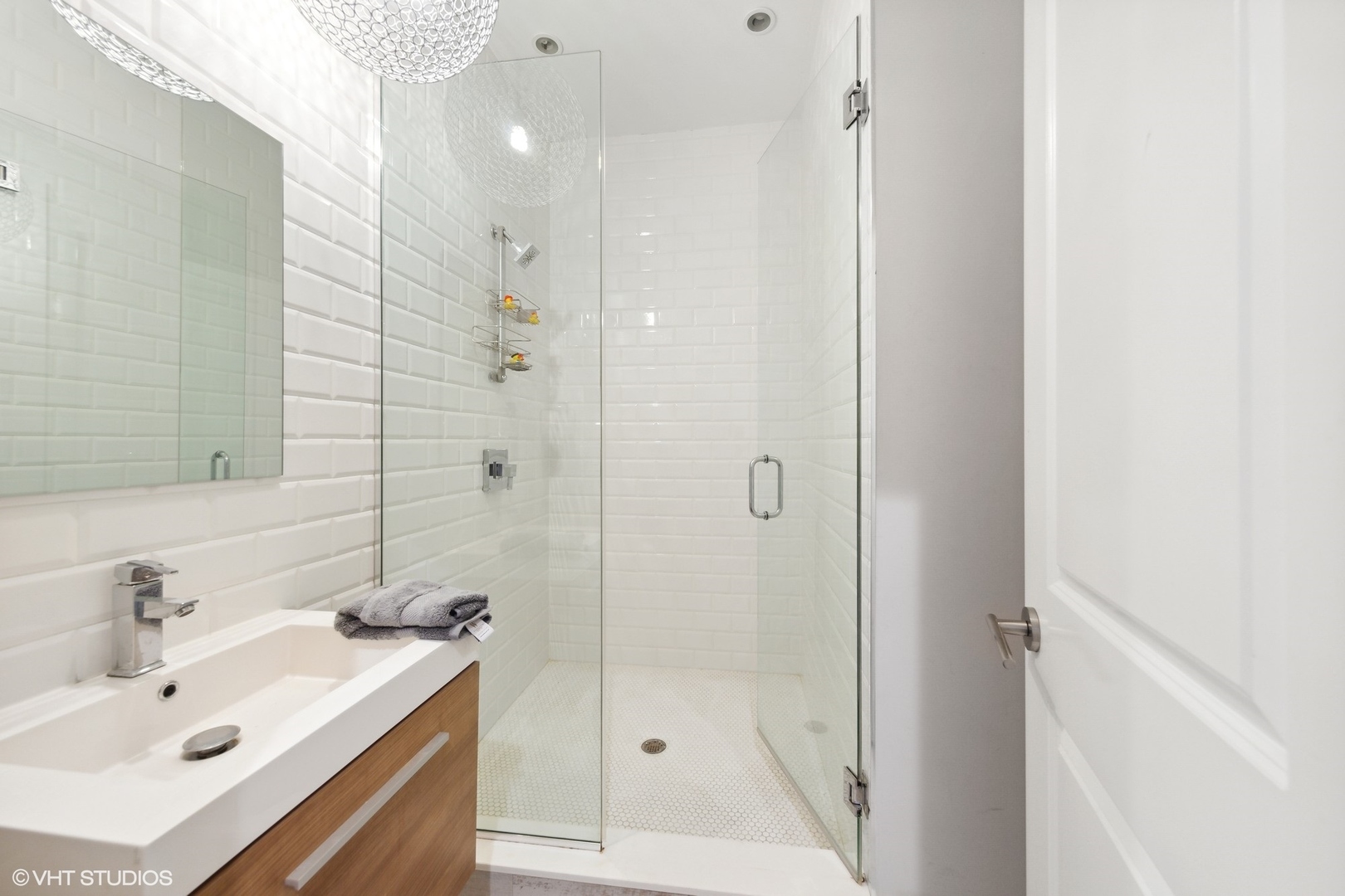 2548 West Irving Park Road, Unit 1E Chicago, IL 60618 - Photo 17 of 17 a bathroom with a shower a sink and a mirror