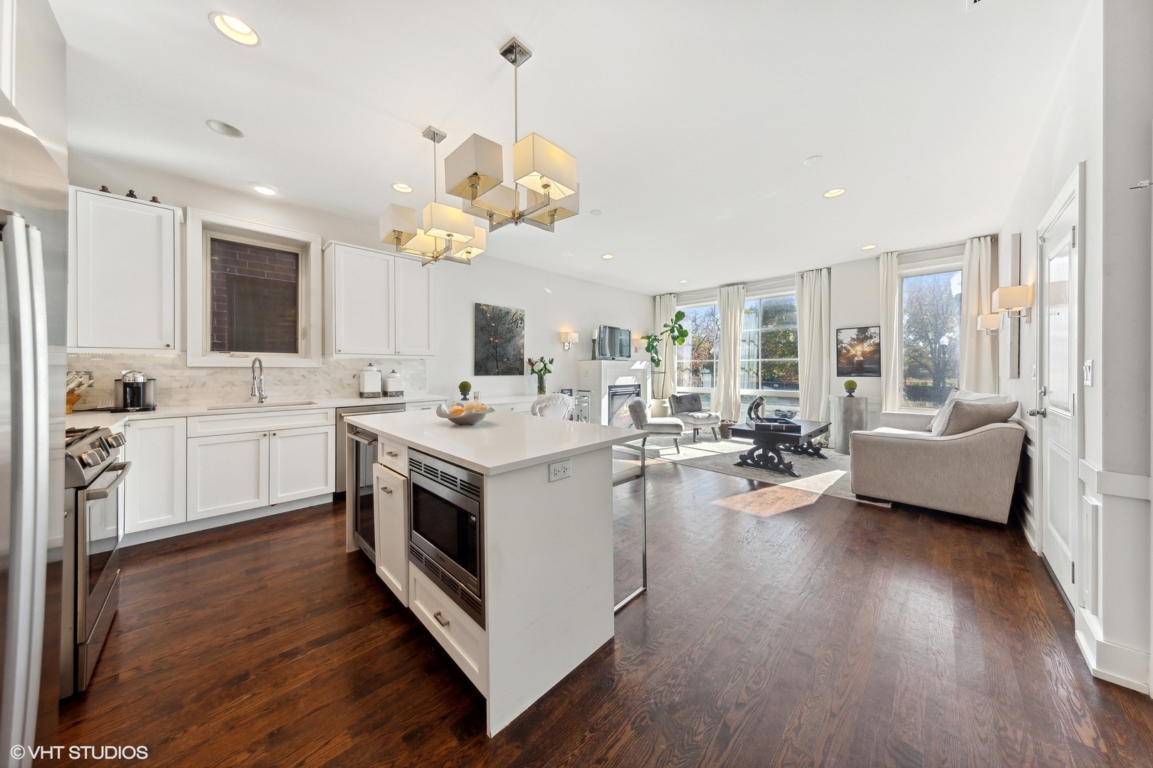 2548 West Irving Park Road, Unit 1E Chicago, IL 60618 - Photo 6 of 17 a kitchen with a sink dishwasher a stove a dining table and chairs with wooden floor