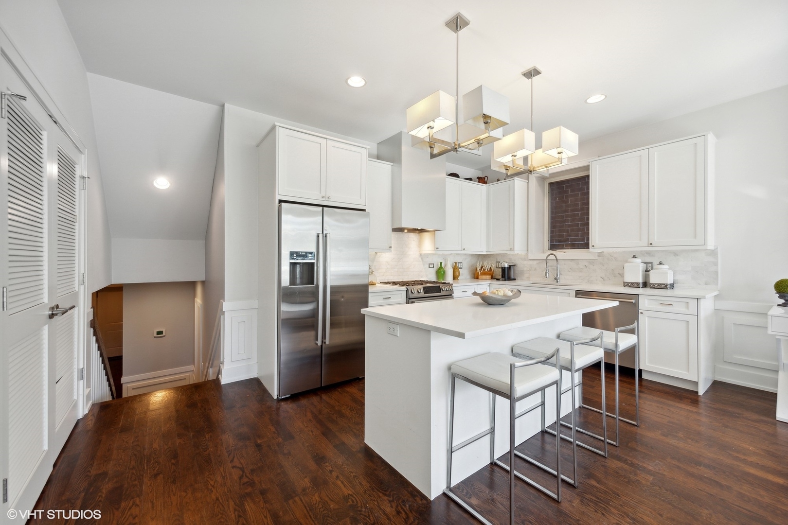 2548 West Irving Park Road, Unit 1E Chicago, IL 60618 - Photo 8 of 17 a kitchen with stainless steel appliances granite countertop a refrigerator a sink dishwasher a dining table and chairs with wooden floor