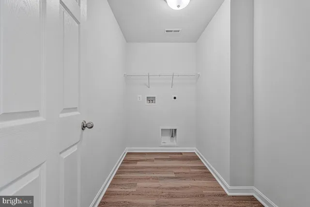 a view of a hallway with wooden floor and entryway