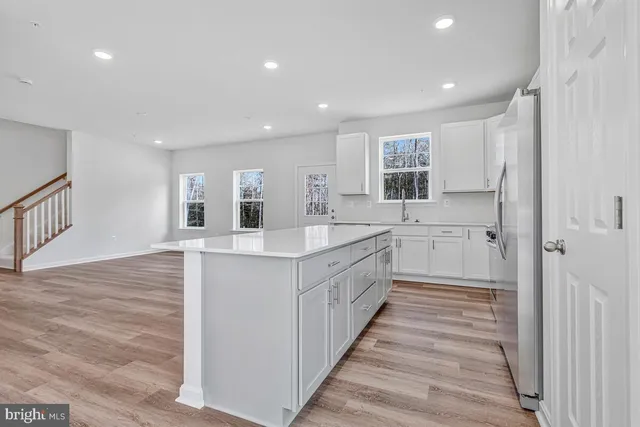 a large white kitchen with a sink and cabinets