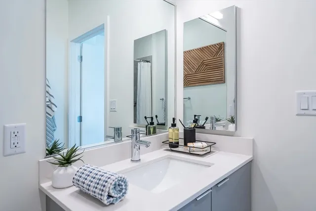 a bathroom with a granite countertop sink and a mirror