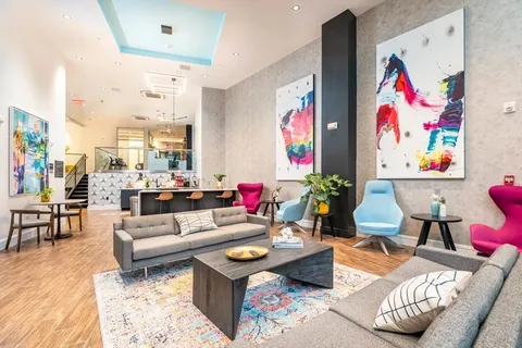 a living room with furniture and painting on the wall