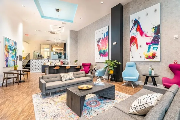 a living room with furniture and painting on the wall