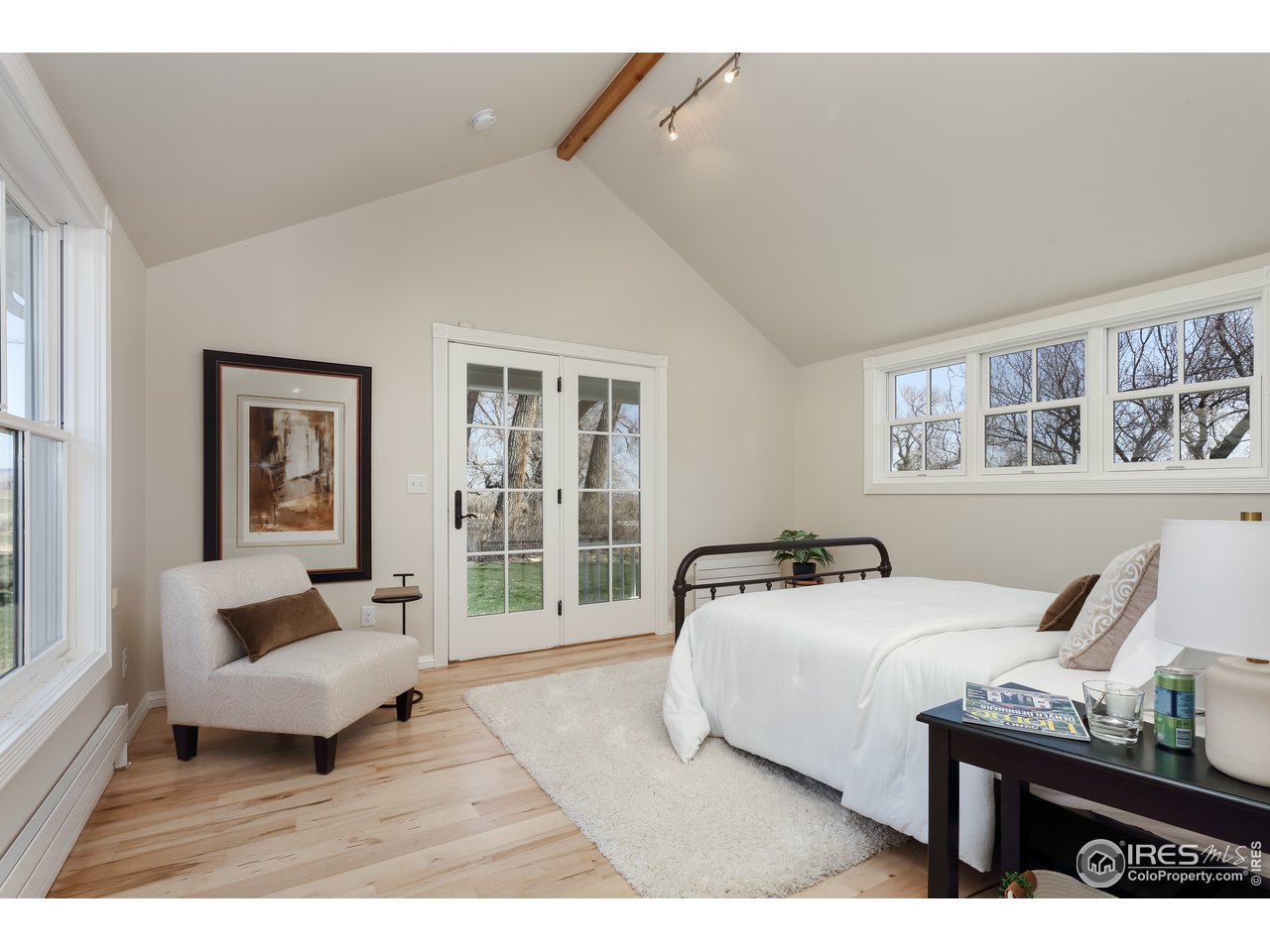 5629 Prospect Road Niwot, CO 80503 - Photo 17 of 40 a spacious bedroom with a bed a couch and large window