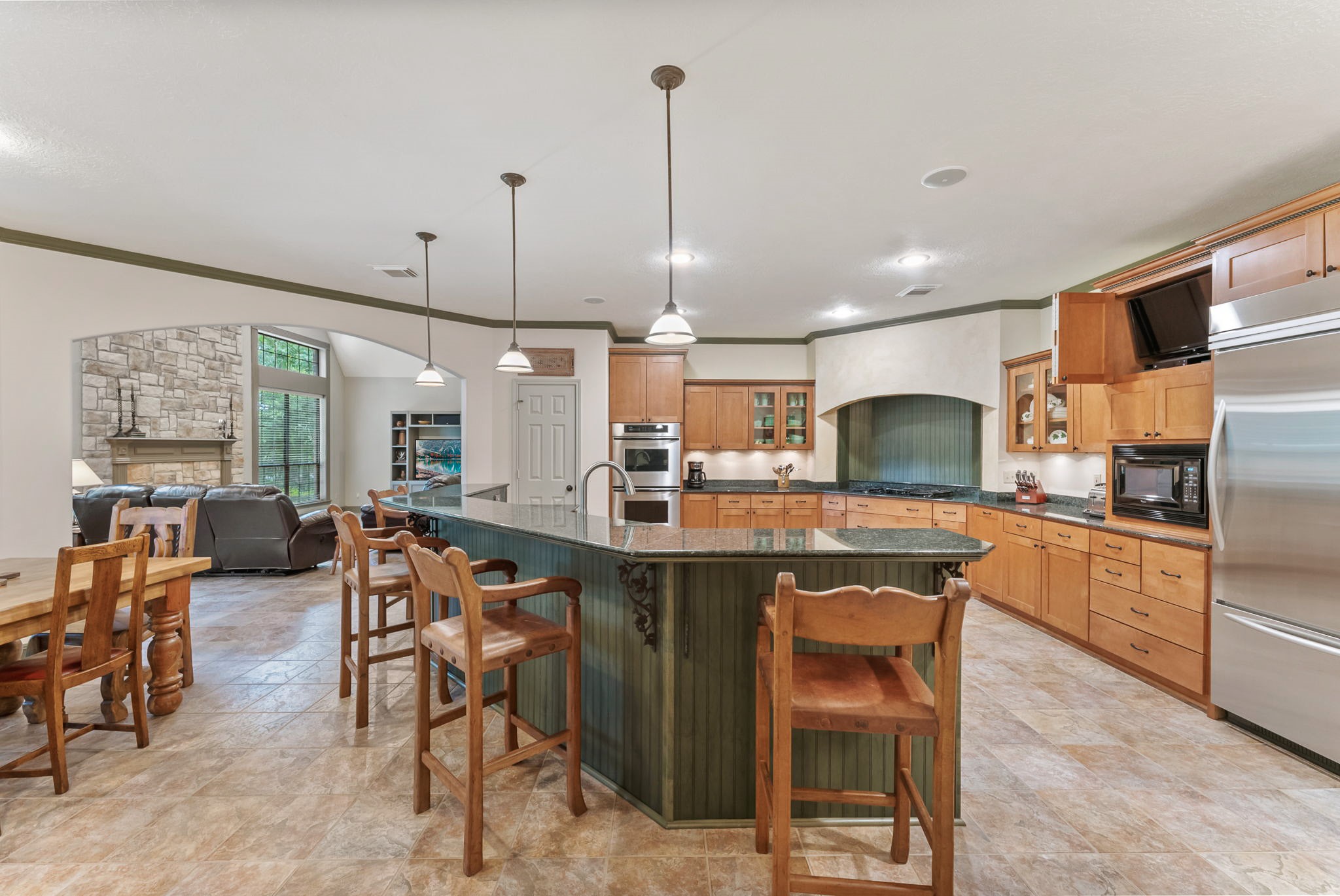 24311 Standing Oak Drive Spring, TX 77389 - Photo 14 of 41 a kitchen with stainless steel appliances granite countertop a sink a stove a refrigerator cabinets dining table and chairs