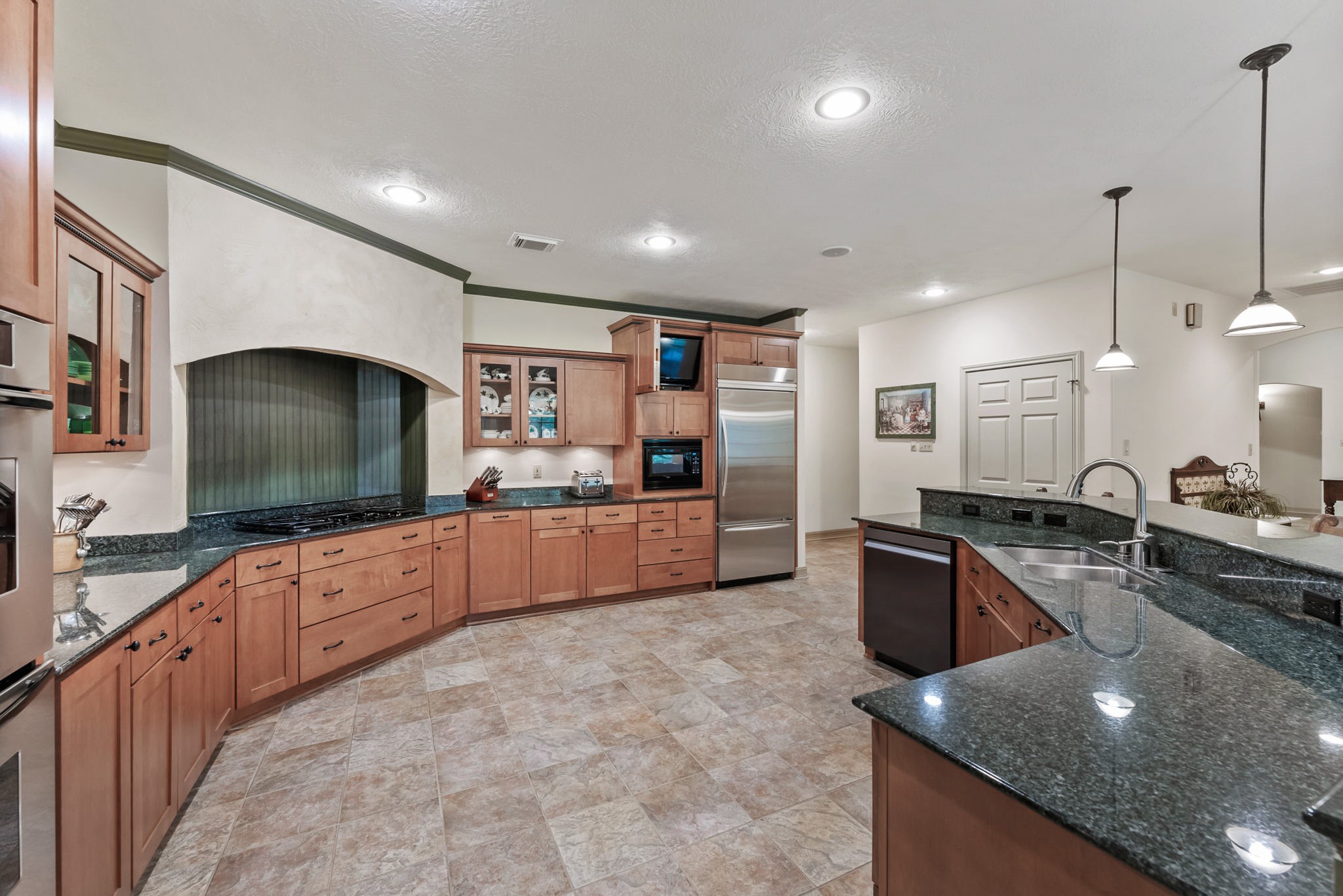 24311 Standing Oak Drive Spring, TX 77389 - Photo 18 of 41 a kitchen with stainless steel appliances granite countertop a sink stove and refrigerator