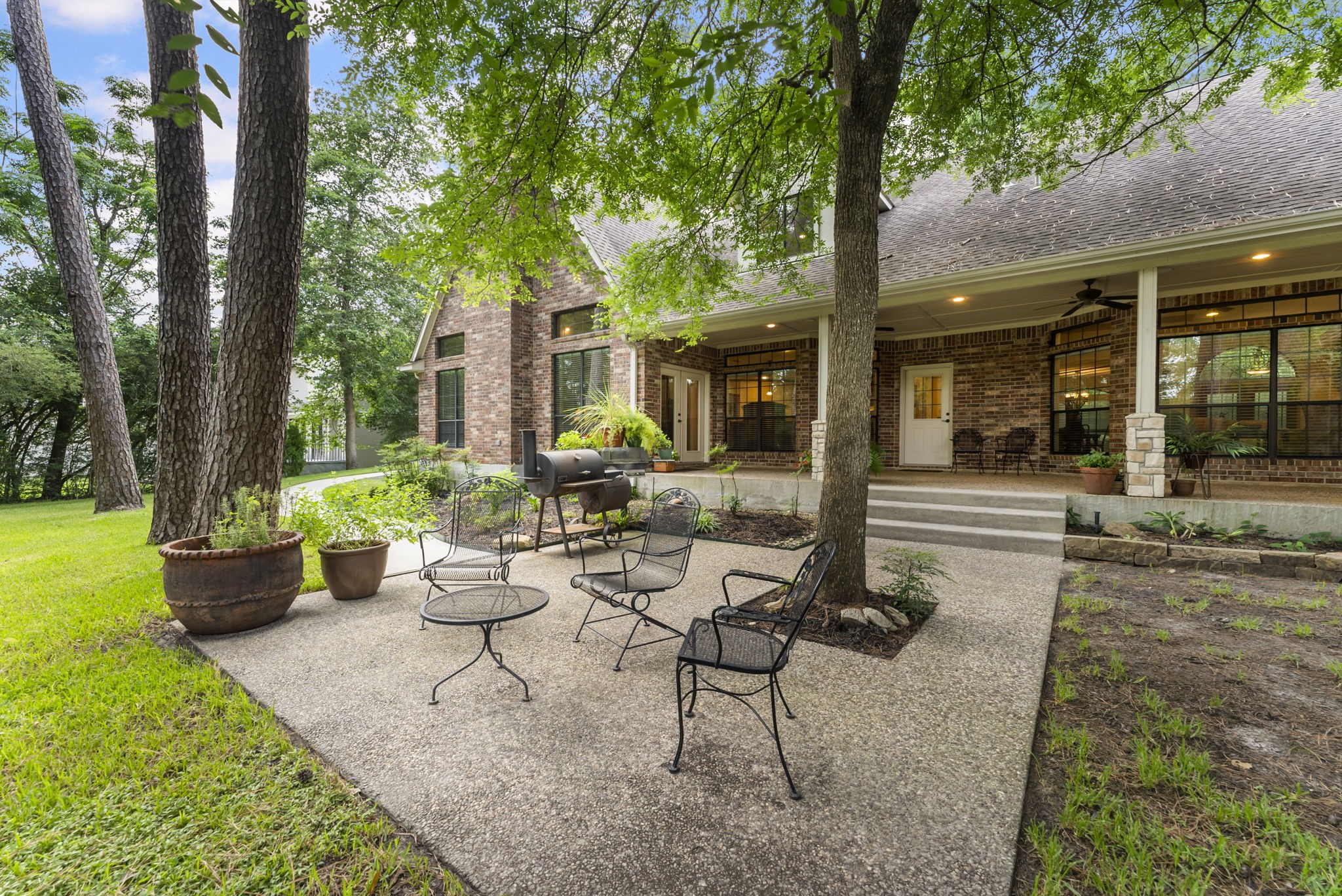 24311 Standing Oak Drive Spring, TX 77389 - Photo 35 of 41 a view of a patio with table and chairs potted plants and large tree