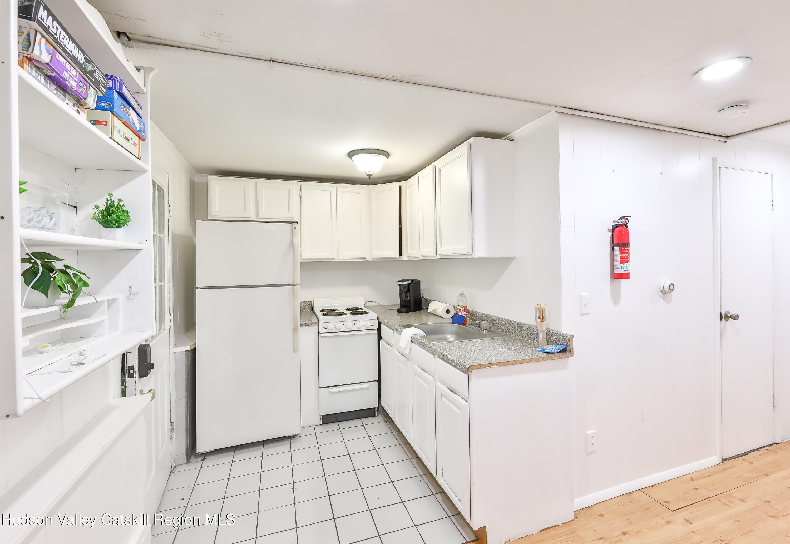 89 Maple Avenue Hunter, NY 12442 - Photo 25 of 41 a kitchen with a sink a refrigerator and white cabinets