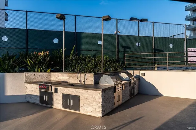 a kitchen with stainless steel appliances granite countertop a sink a stove and a wooden floors