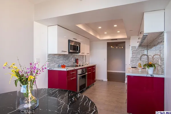 a kitchen with stainless steel appliances kitchen island granite countertop a stove refrigerator and microwave
