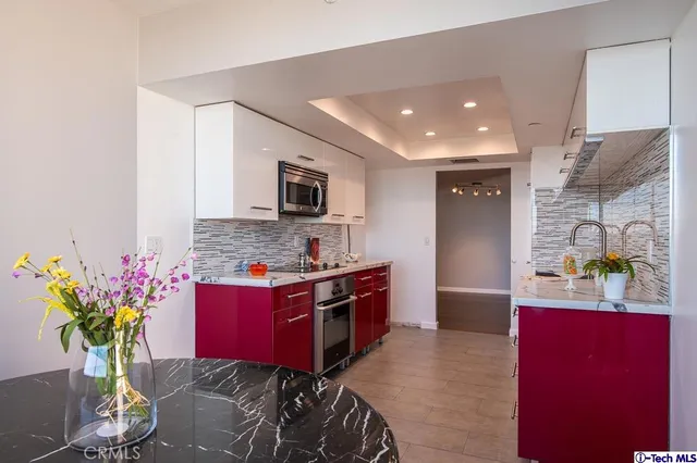 a kitchen with stainless steel appliances kitchen island granite countertop a stove refrigerator and microwave