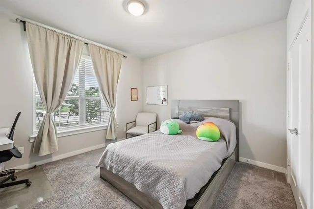 a bedroom with a bed a window and walk in closet