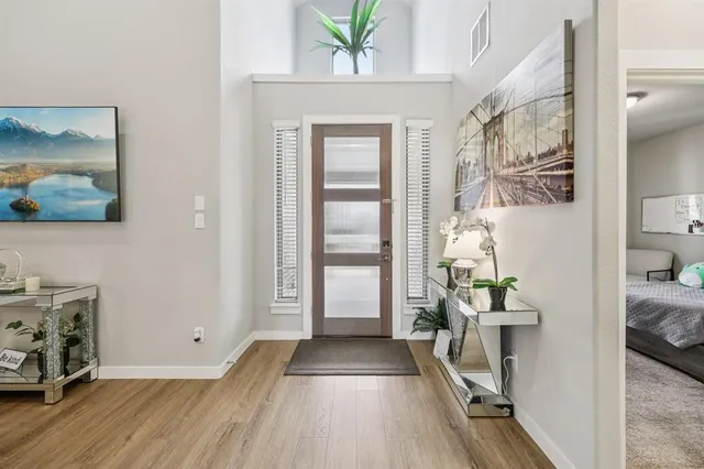 a view of a hallway to a livingroom with furniture and windows