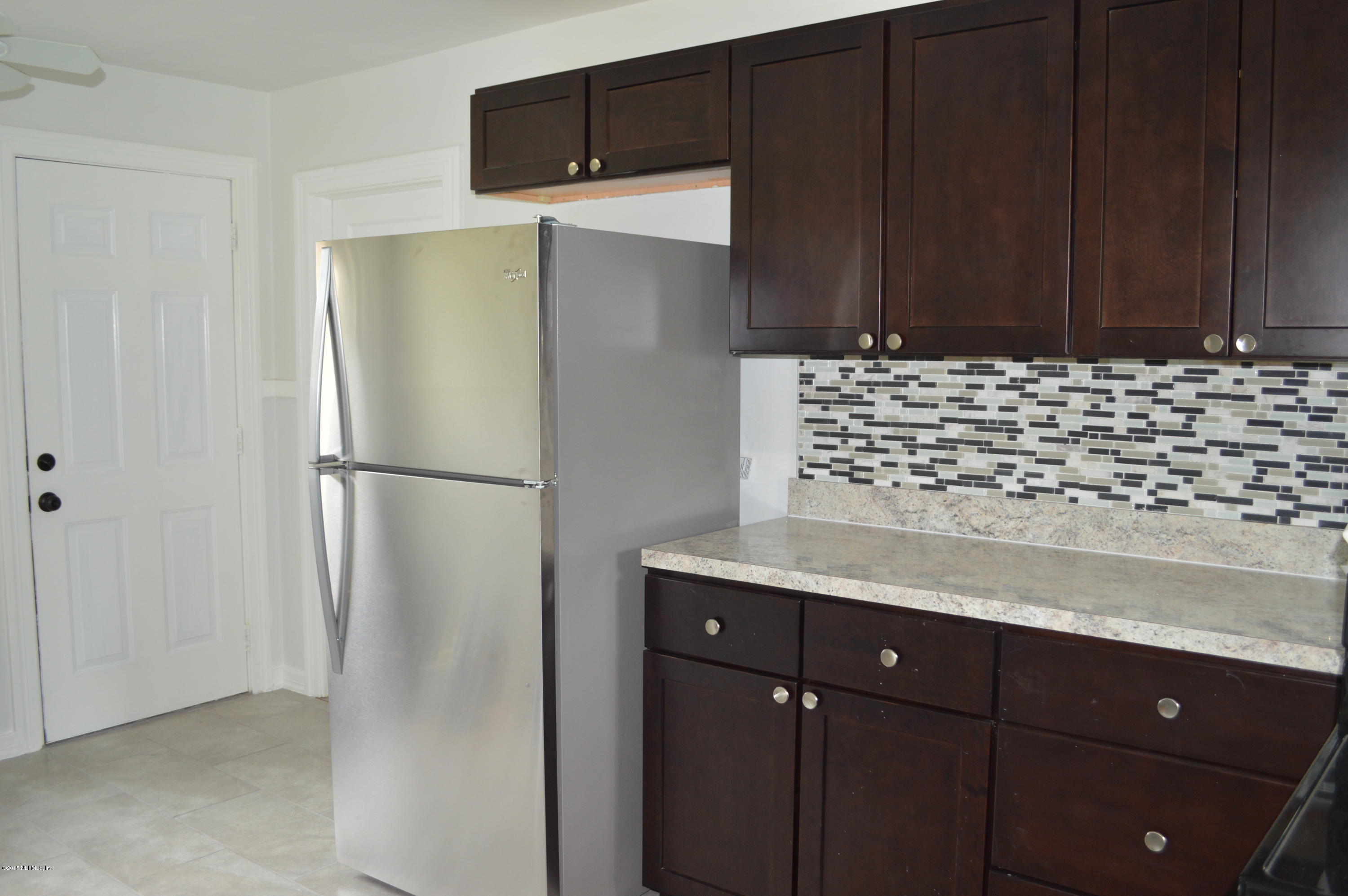 4603 Sunderland Road Jacksonville, FL 32210 - Photo 12 of 20 a kitchen with a refrigerator and cabinets