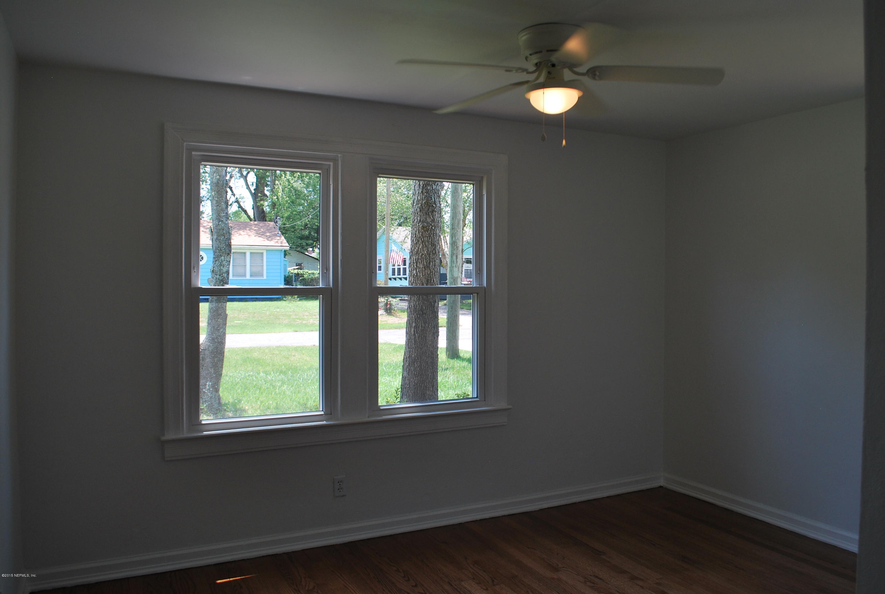 4603 Sunderland Road Jacksonville, FL 32210 - Photo 13 of 20 an empty room with wooden floor and windows