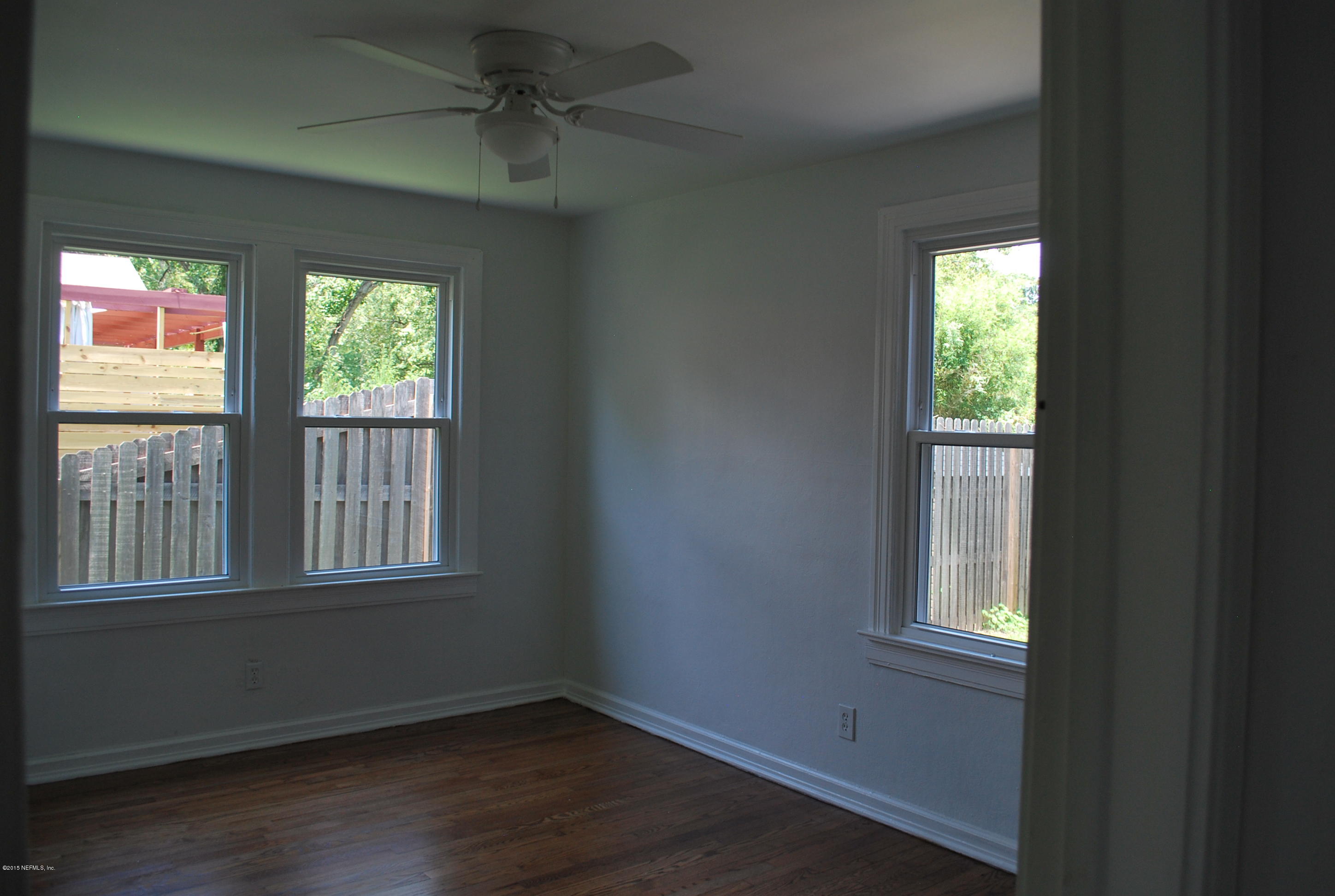 4603 Sunderland Road Jacksonville, FL 32210 - Photo 14 of 20 a view of an empty room with wooden floor and a window
