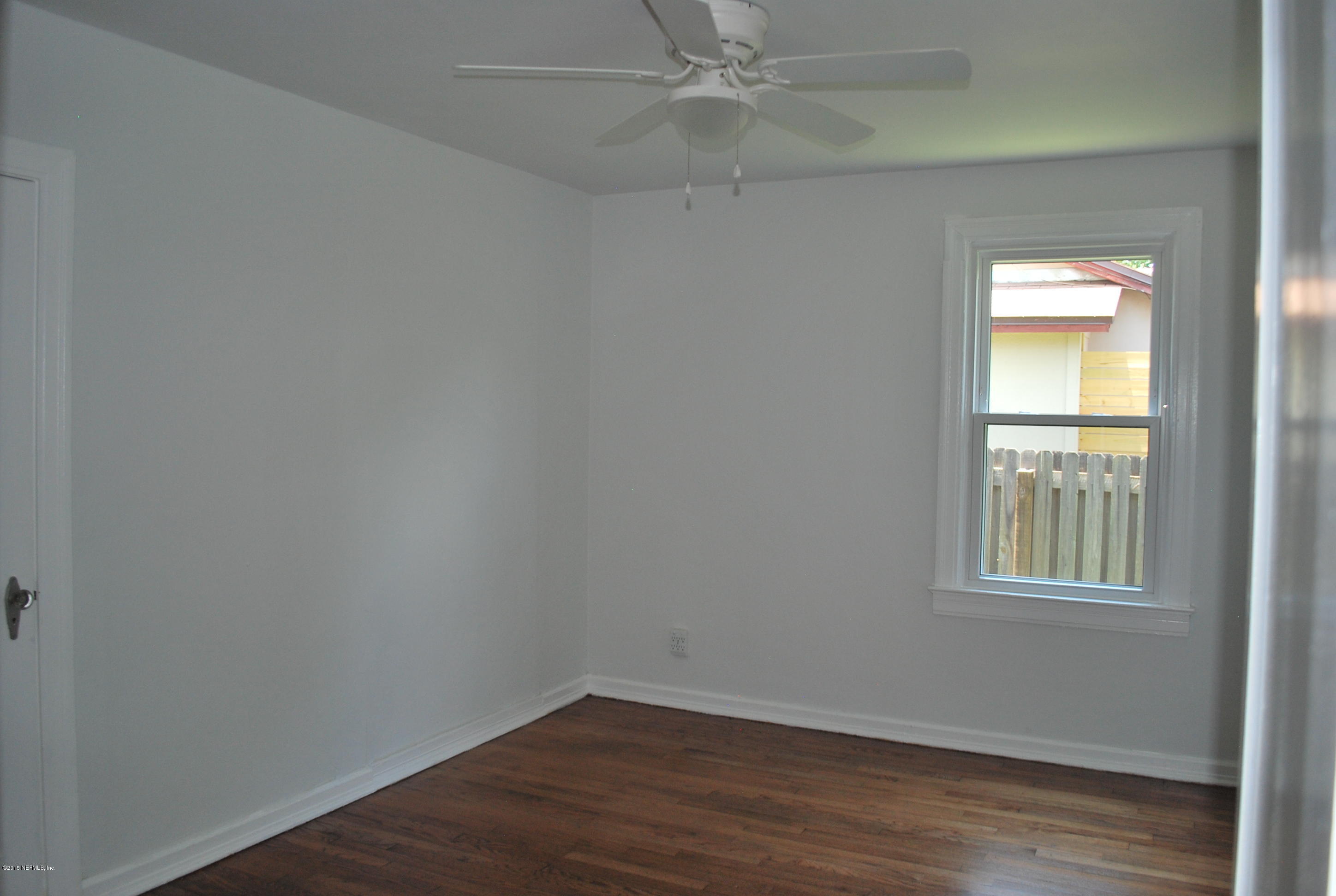 4603 Sunderland Road Jacksonville, FL 32210 - Photo 15 of 20 an empty room with wooden floor and windows