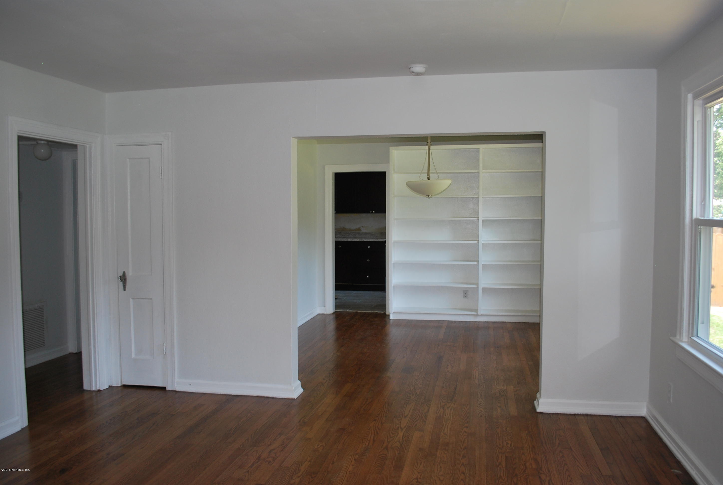 4603 Sunderland Road Jacksonville, FL 32210 - Photo 8 of 20 a view of an empty room with wooden floor and a window